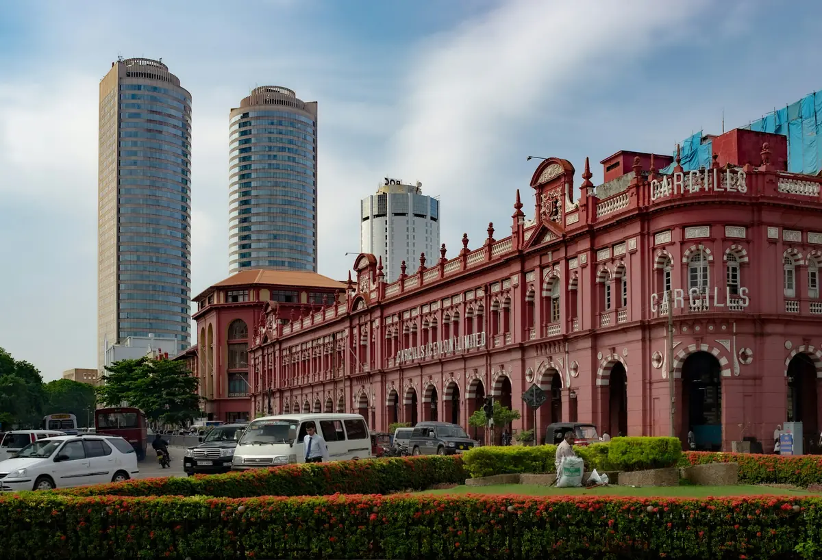 Historic red-brick building in Colombo Fort with modern towers behind