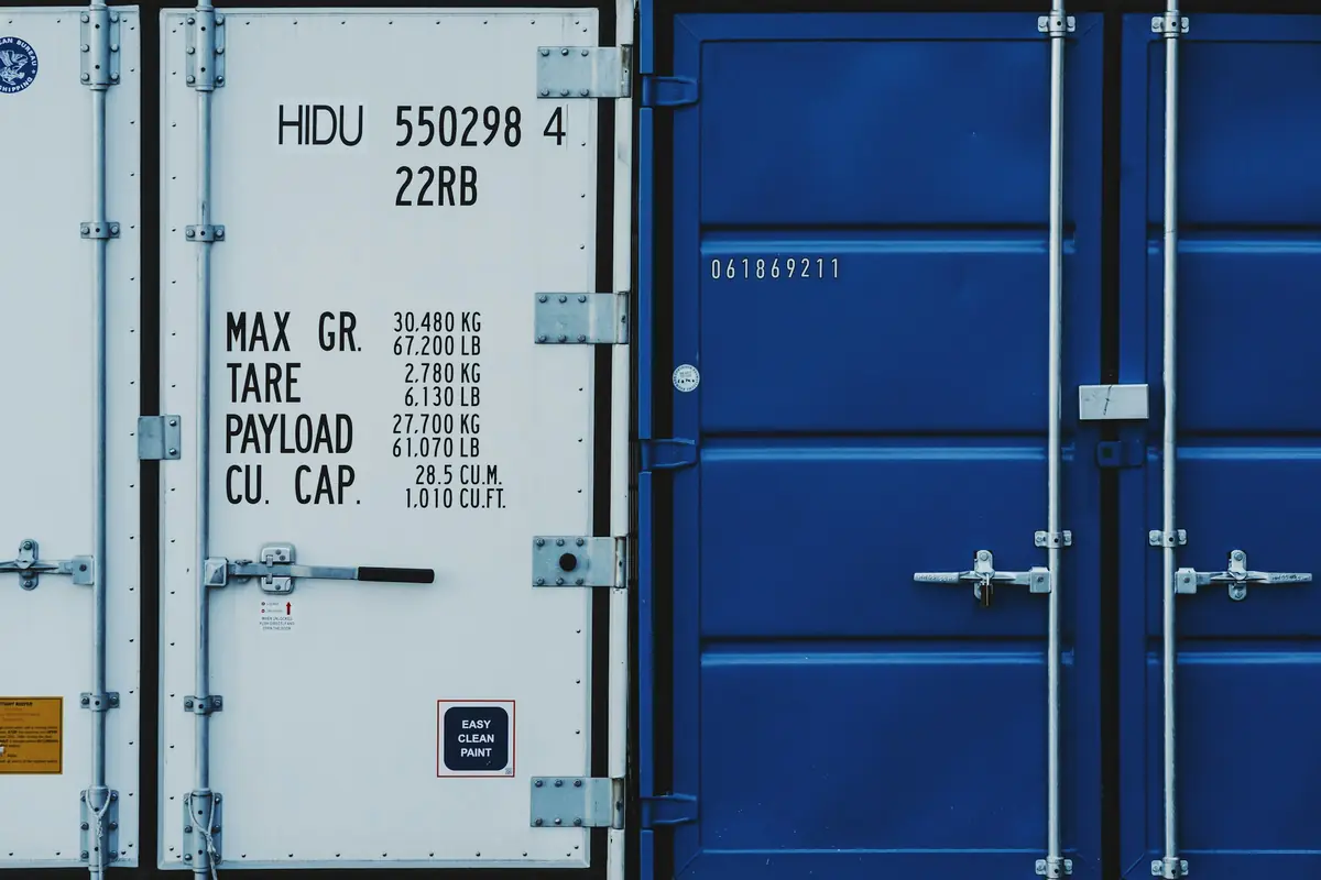 Close-up of a shipping container door with stencilled tare and payload markings