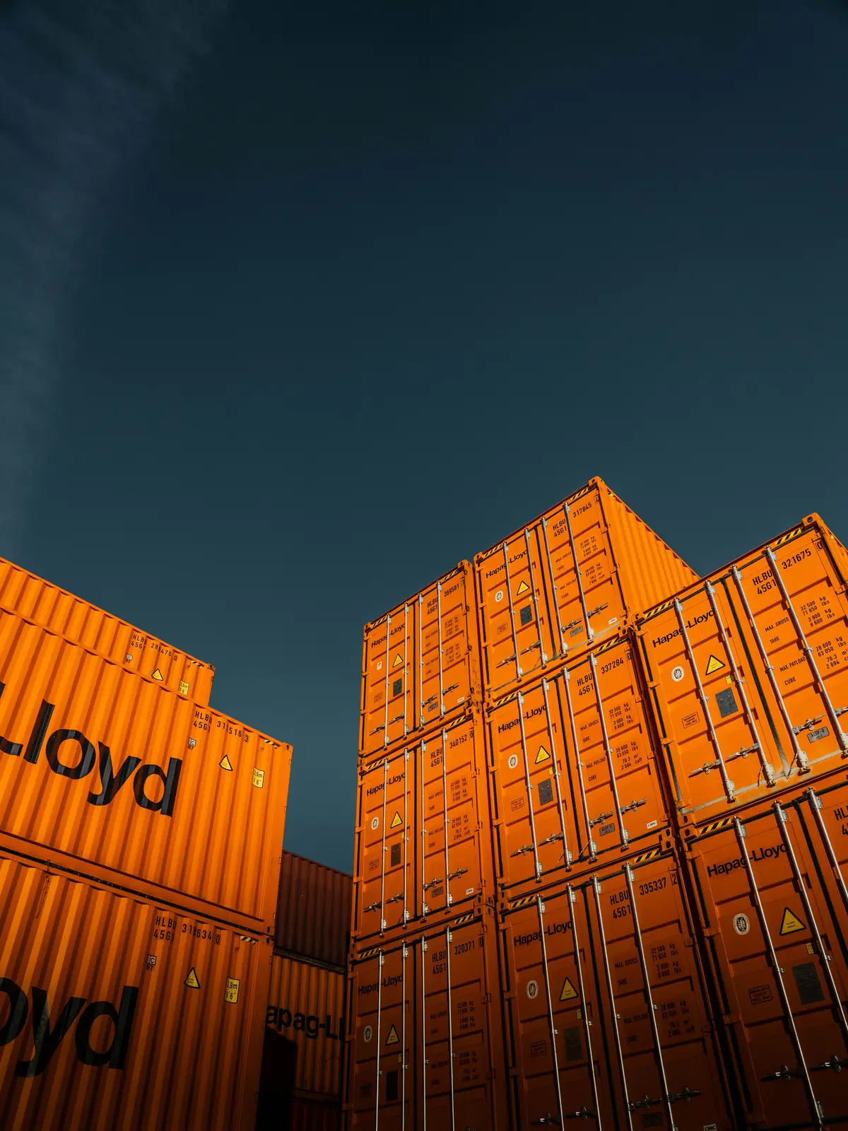 Looking up between stacks of orange shipping containers
